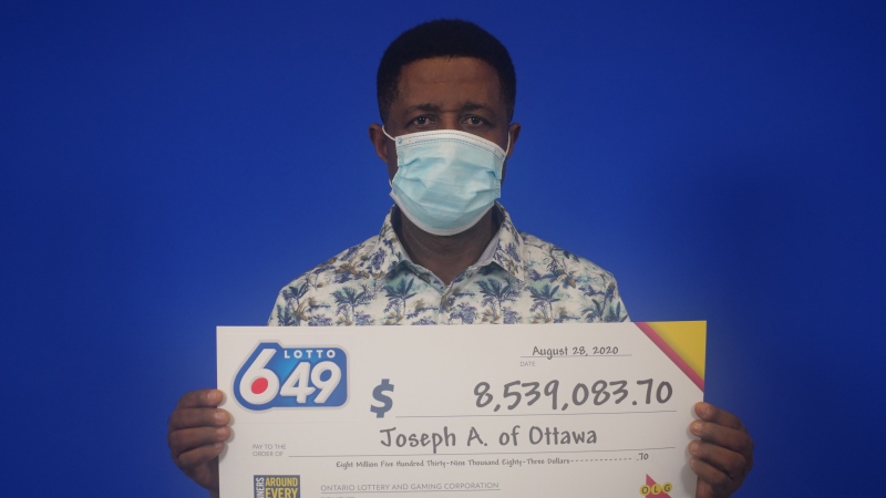 Ottawa's Joseph Anokye picks up his $8.5 million prize after winning the Lotto 6/49 jackpot on July 22. (Photo courtesy: OLG)