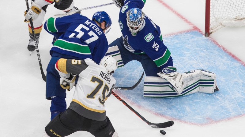 Vancouver Canucks goalie Thatcher Demko (35) makes a save on Vegas Golden Knights' Ryan Reaves (75) as Canucks' Tyler Myers (57) defends during third period NHL Western Conference Stanley Cup playoff action in Edmonton on Thursday, September 3, 2020. THE CANADIAN PRESS/Jason Franson