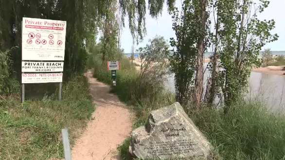 A walkway along a private beach in Port Franks shows signage about the area.
(Brent Lale / CTV London) 