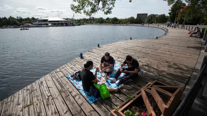 A family picnics on the boardwalk at Dows Lake in Ottawa on the Labour Day long weekend, Sunday, Sept. 6, 2020. (Justin Tang/THE CANADIAN PRESS)