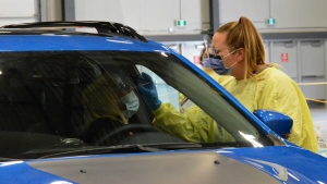 A staff member at the Regina drive-through testing station swabs a woman for COVID-19. (Jeremy Simes/CTV Regina)