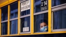 A student peers through the window of a school bus as he arrives at the Bancroft Elementary School in Montreal, on August 31, 2020. THE CANADIAN PRESS/Paul Chiasson