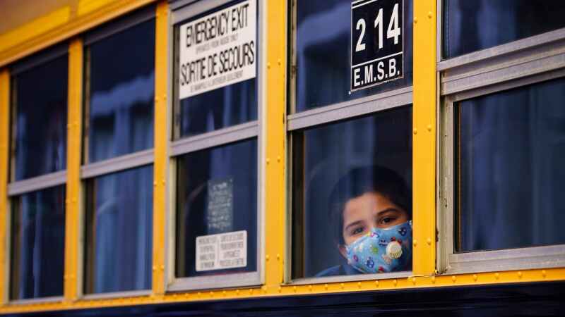 A student peers through the window of a school bus. (Paul Chiasson/THE CANADIAN PRESS)