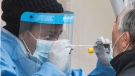 A health-care worker prepares to swab a man at a walk-in COVID-19 test clinic in Montreal North, Sunday, May 10, 2020. (THE CANADIAN PRESS/Graham Hughes)