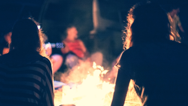 People sit around a campfire. (Shutterstock)