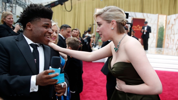 In this Feb. 9, 2020 file photo, Greta Gerwig, right, talks to Jerry Harris on the red carpet at the Oscars at the Dolby Theatre in Los Angeles. (AP Photo/John Locher File)