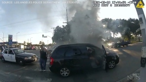 Bodycam footage shows LAPD officers rushing to rescue a man in a wheelchair from a smoky car wreck moment before it bursts in flames.
