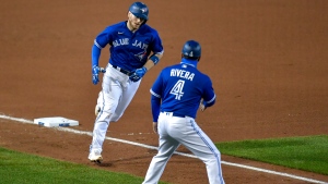 Toronto Blue Jays' Danny Jansen, left, is congratulated by third base coach Luis Rivera (4) after hitting a solo home run against the New York Yankees during the fourth inning of a baseball game in Buffalo, N.Y., Wednesday, Sept. 23, 2020. (AP Photo/Adrian Kraus)