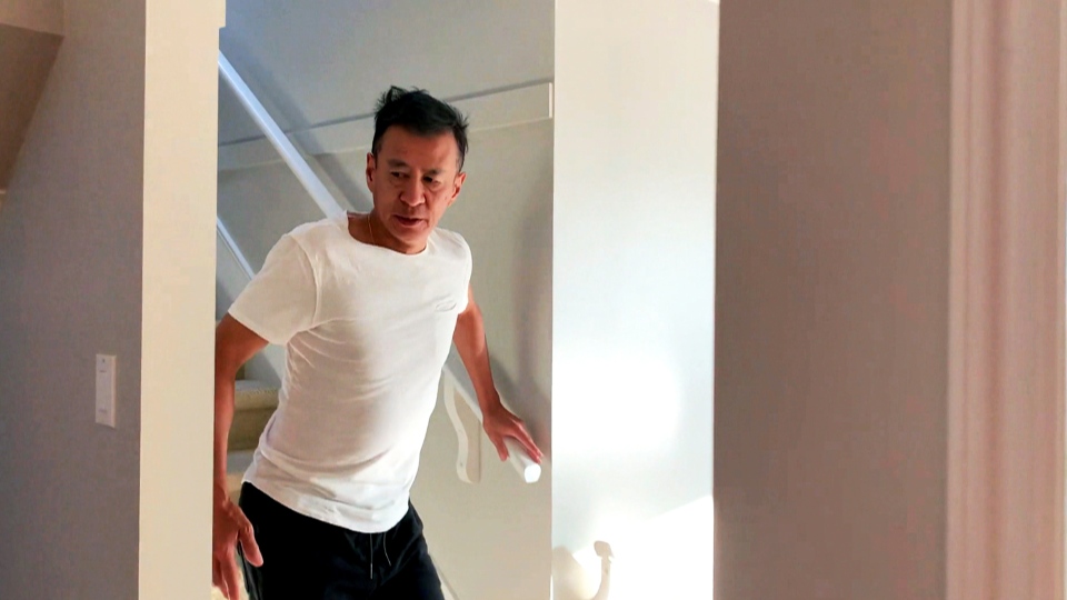 Dr. Michael Chow walks down stairs in his home
