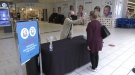 A Woodgrove Centre employee takes the temperature reading of a customer as she enters the mall. (CTV News)