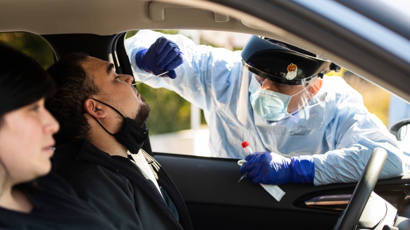 A paramedic administers a nasal swab at a drive through, pop-up COVID-19 test centre outside the Canadian Tire Centre in Ottawa, Sunday, Sept. 20, 2020. THE CANADIAN PRESS/Justin Tang