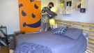 Erick Cole fixing the sheets on the bed he built himself. (Dave Charbonneau / CTV News Ottawa)
