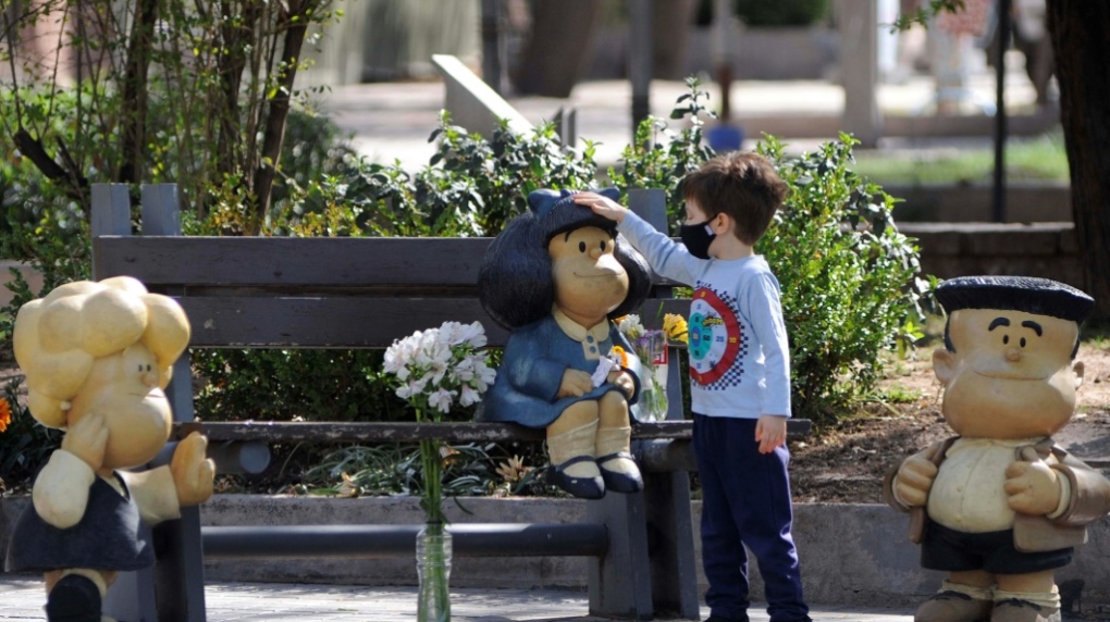 Child touches a Mafalda statue