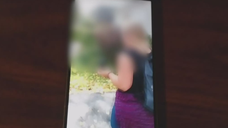 This blurred image from video shows two people distributing anti-abortion flyers in London, Ont.