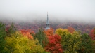 Low clouds hover over a church spire and fall colours, Friday October 2, 2020 in Chelsea, Que. (Adrian Wyld/THE CANADIAN PRESS)