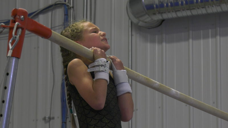 An Estevan gymnast holds a chin-up as part of a strength competition with the SJHL's Estevan Bruins on Thursday. (Claire Hanna / CTV News Regina)