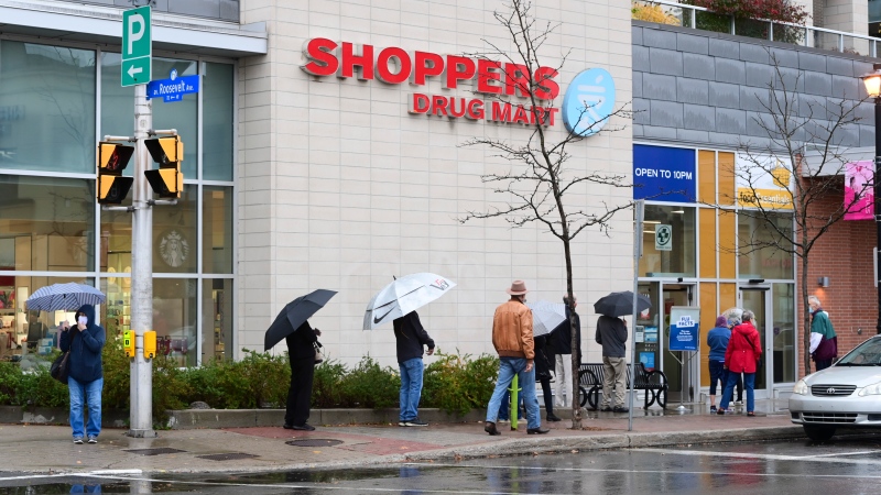 People line up to get an annual flu shot at a pharmacy in Ottawa on Thursday, Oct. 15, 2020. (Sean Kilpatrick/THE CANADIAN PRESS)