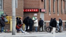 FILE- People gather outside of a shelter in downtown Toronto on Saturday, March 28, 2020. THE CANADIAN PRESS/Colin Perkel