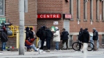 FILE- People gather outside of a shelter in downtown Toronto on Saturday, March 28, 2020. THE CANADIAN PRESS/Colin Perkel