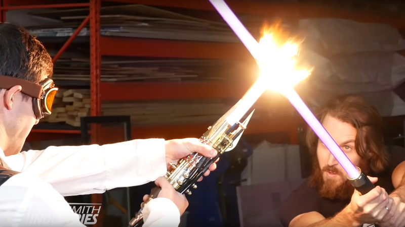 A screen grab from plasma-based lightsaber testing video shows the device (left) in action against a look-alike lightsaber. (the Hacksmith / YouTube)