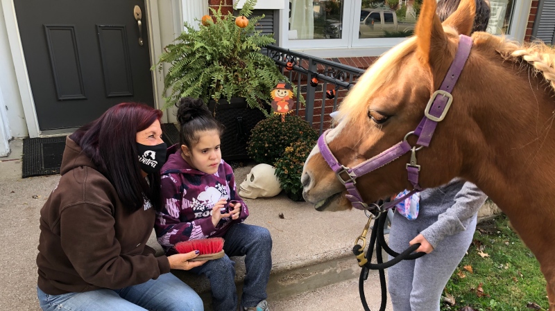 Vanessa and Criztina Muscat getting a home visit from one of WETRA's ponys in Windsor, Ont. on Tuesday, Oct. 20 2020. (Angelo Aversa/CTV Windsor)
