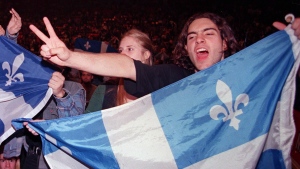 A Yes supporter holding a Quebec flag chants nationalist slogans prior to a concert of Quebec rock stars in support of sovereignty in Montreal Friday Sept. 29, 1995. THE CANADIAN PRESS/Paul Chiasson