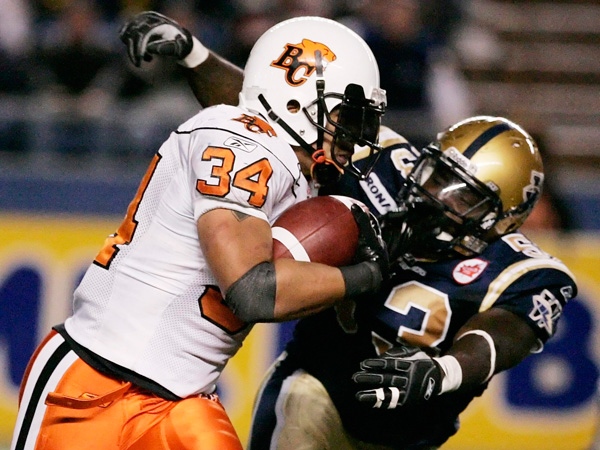 Winnipeg Blue Bombers' Phillip Hunt (53) attempts to wrap up BC Lions' A.J. Harris (34) in second half CFL action in Winnipeg, Sunday, October 18, 2009. THE CANADIAN PRESS/John Woods 