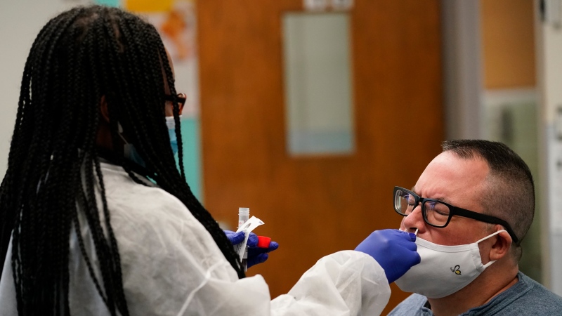 Instructor Frank Esposito submits to a COVID-19 nasal swab test at West Brooklyn Community High School, Thursday, Oct. 29, 2020, in New York. (AP Photo/Kathy Willens)
