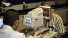 Dr. Manuel Datiles of the National Eye Institute, left, tests an eye device on NASA scientist Rafat Ansari. (AP/NASA)