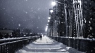 A pedestrian walks across Alexandra Bridge during snowfall.  (Photo by Marc-Olivier Jodoin of Unsplash)