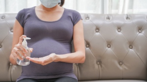 A pregnant woman wearing a mask. (Shutterstock)