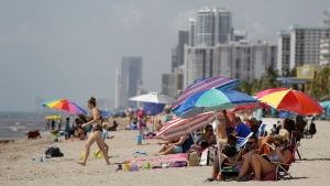 People sit on Hollywood Beach during the coronavirus pandemic, Thursday, July 2, 2020, in Hollywood, Fla. (AP Photo/Lynne Sladky)