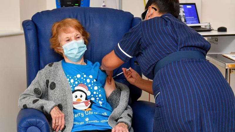 90 year old Margaret Keenan, the first patient in the UK to receive the Pfizer-BioNTech COVID-19 vaccine, administered by nurse May Parsons at University Hospital, Coventry, England, Tuesday Dec. 8, 2020. (Jacob King/Pool via AP)