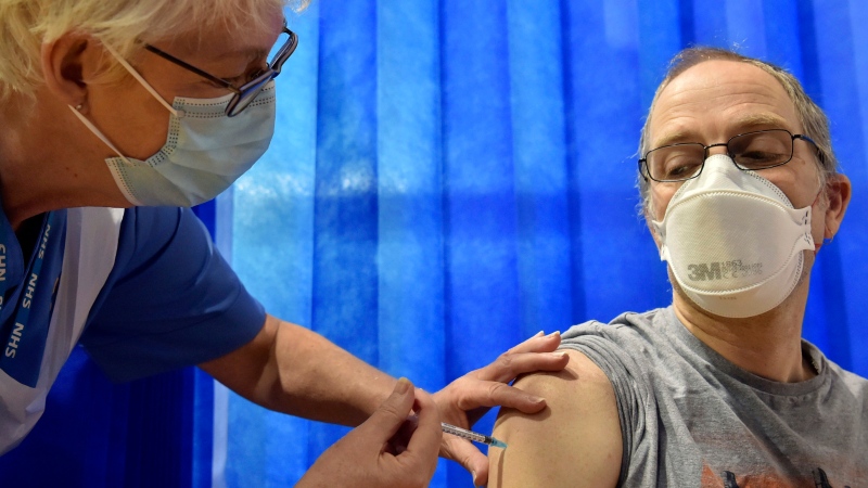 David Farrell, 51, receives the Pfizer-BioNTech COVID-19 vaccine at a vaccination centre in Cardiff, Wales, Tuesday Dec. 8, 2020. (Ben Birchall/Pool via AP)
