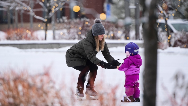 A mom teachers her daughter to skate at Landsdowne Park in Ottawa on Wednesday, Dec. 9, 2020. (Sean Kilpatrick/THE CANADIAN PRESS)