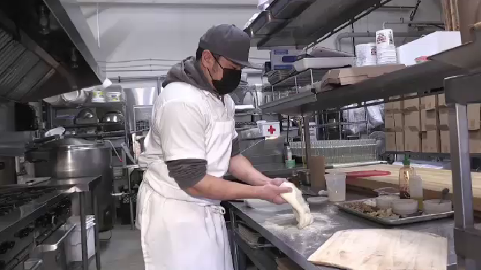 Thompson Tran works on a pizza
