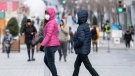 People wear face masks as they walk along a street in Montreal, Saturday, December 5, 2020, as the COVID-19 pandemic continues in Canada and around the world. THE CANADIAN PRESS/Graham Hughes