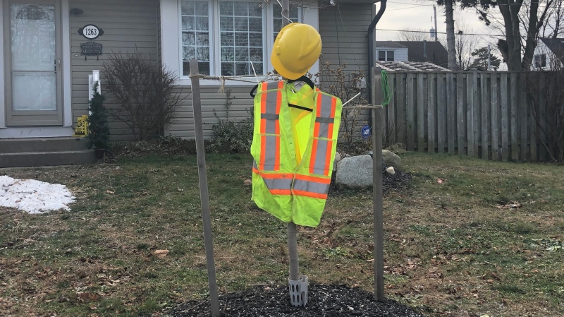 A construction vest is seen hanging outside a home on Landor Street in London, Ont. on Tuesday, Dec. 15, 2020, as a tribute to two workers killed in a building collapse. (Jim Knight / CTV News)