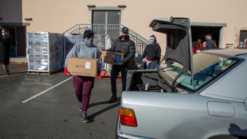 Volunteers load food into vehicles