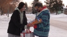 Liz Settee gives 15-year-old Paige Smith a food hamper on Dec. 16, 2020. Smith is passing the hamper on to her sister to help feed her family.