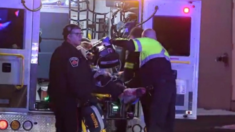 A man is loaded into an ambulance after he was attacked with a knife at a men's shelter on Dec. 17, 2020.