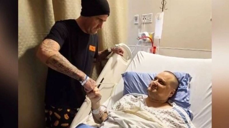 Hot dog vendor Andrew "Skully" White shakes hands with the regular customer who received his donated kidney.  