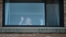 Alicia Tamayo, left, 95, waves to her daughter Betty Fernandez from her window at the Eatonville Care Centre where multiple deaths from COVID-19 have occurred in Toronto on Tuesday, April 14, 2020. THE CANADIAN PRESS/Nathan Denette