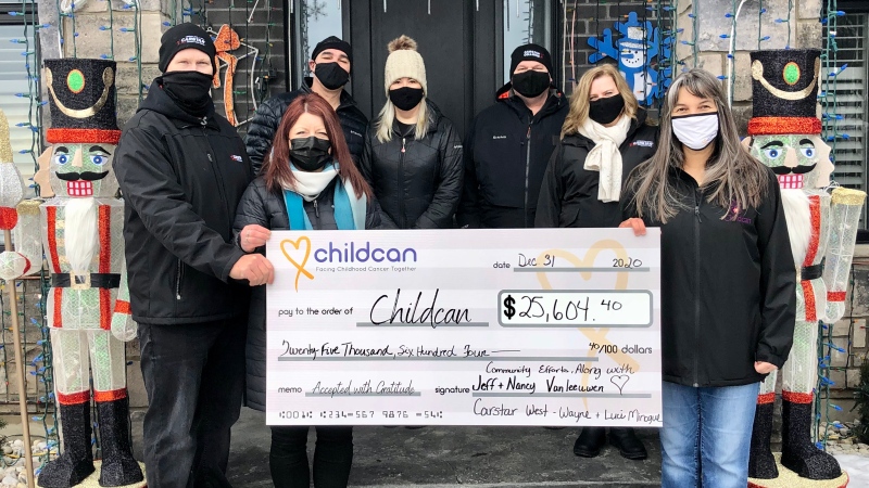 The Vanleeuwen family presents a cheque to Childcan in Ilderton, Ont. on Thursday, Dec. 31, 2020. (Jim Knight / CTV News)