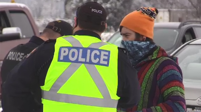 Police speak with a protestor who entered Church of God property in Aylmer, Ont. on Jan. 3, 2021. (Brent Lale/CTV London)