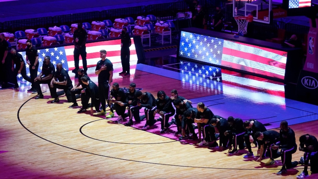 The Boston Celtics team kneels