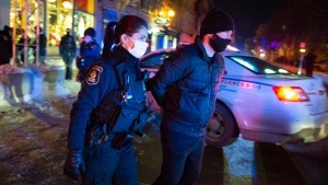 A man is arrested by police after 8 p.m. as a curfew begins in the province of Quebec to counter the spread of COVID-19 on Saturday, January 9, 2021 in Quebec City. A handful of demonstrators walked downtown to protest the curfew. THE CANADIAN PRESS/Jacques Boissinot