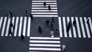 People wearing protective masks to help curb the spread of the coronavirus walk along pedestrian crossings in the Ginza shipping area of Tokyo, Friday, Jan. 8, 2021. (AP Photo/Eugene Hoshiko)