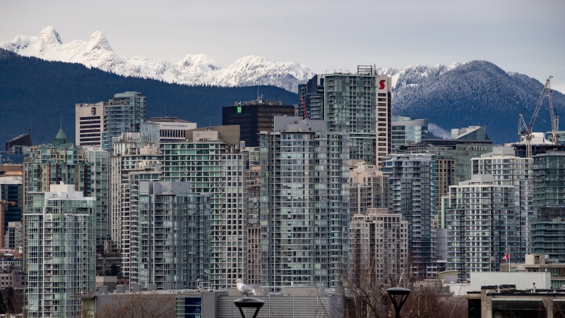 Condo and office towers are seen in downtown Vancouver, with the snow-capped north shore mountains in the distance, on Saturday, Jan. 9, 2021. (Darryl Dyck / THE CANADIAN PRESS)