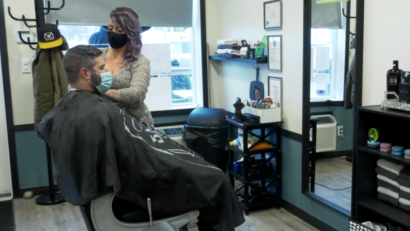 Natalie Klein, co-owner of Bladez 2 Fadez in Innisfail, Alta., serves a client in the barbershop on Jan. 12